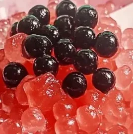 Homemade watermelon popping boba served in a clear cup with fresh watermelon slices