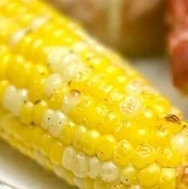 Delicious air fryer corn on the cob served with butter and herbs.
