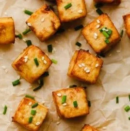 Crispy air fryer tofu served on a plate with vegetables