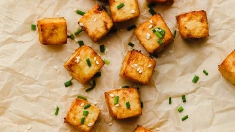 Crispy air fryer tofu served on a plate with vegetables