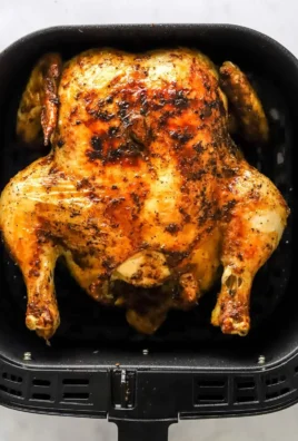 Air fryer whole chicken cooked to perfection with crispy skin and juicy meat.