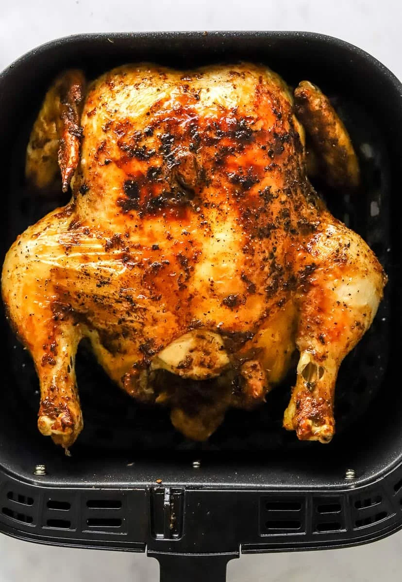 Air fryer whole chicken cooked to perfection with crispy skin and juicy meat.