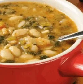Bowl of nutritious anti inflammatory soup with fresh vegetables and herbs.