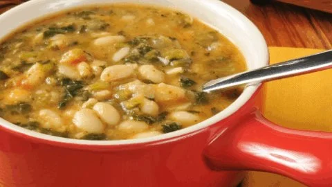 Bowl of nutritious anti inflammatory soup with fresh vegetables and herbs.