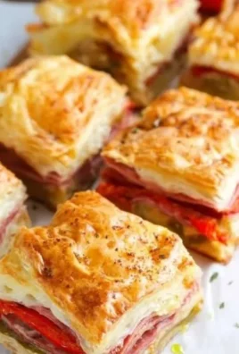 Plate of colorful antipasto squares with assorted meats, cheeses, and vegetables