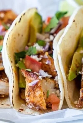 Baked fish tacos topped with fresh ingredients in warm tortillas