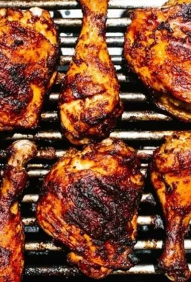 Delicious BBQ Chicken sizzling on the grill with BBQ sauce