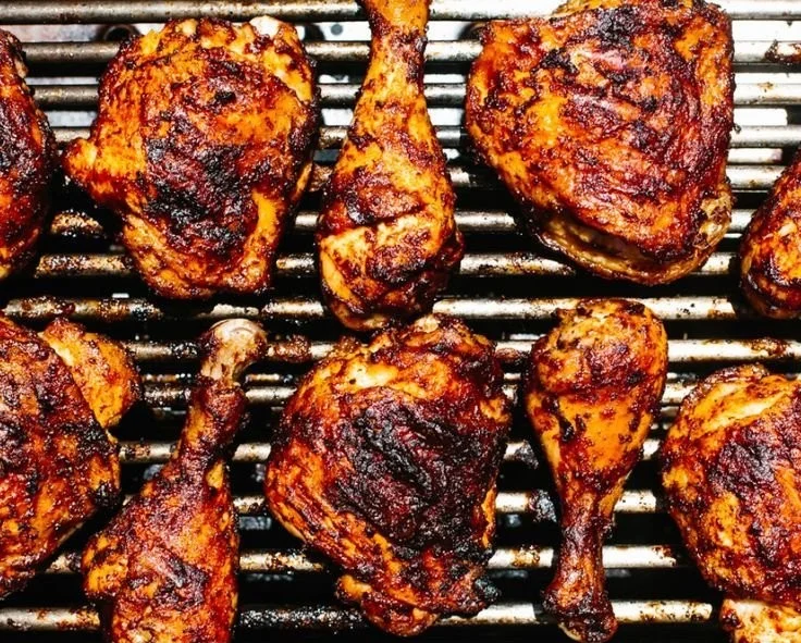 Delicious BBQ Chicken sizzling on the grill with BBQ sauce