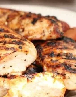 Delicious grilled chicken breast cooked on a smoker grill with smoky flavor.