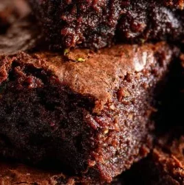 Delicious chocolate zucchini brownies topped with chocolate chips on a plate