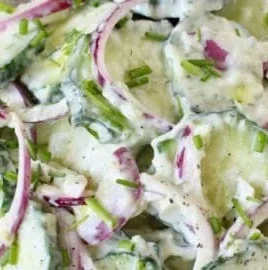 Creamy cucumber yogurt salad served in a bowl with herbs.