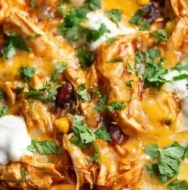 Crockpot chicken enchilada casserole topped with cheese and fresh ingredients