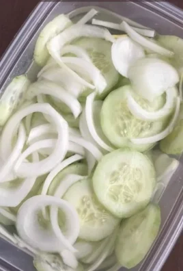 Fresh Cucumber Onion Salad served in a bowl garnished with herbs