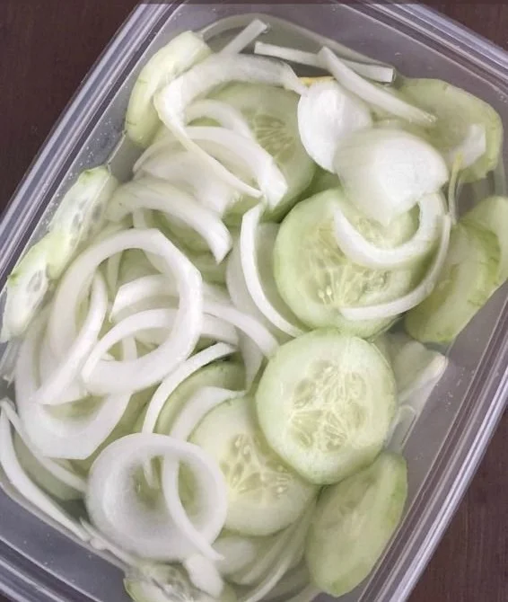 Fresh Cucumber Onion Salad served in a bowl garnished with herbs