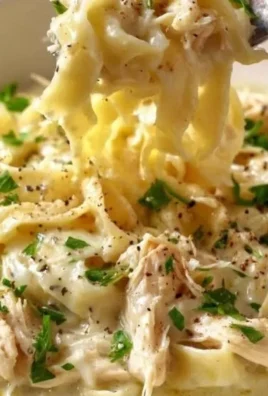 Bowl of easy creamy chicken noodles topped with parsley and pepper