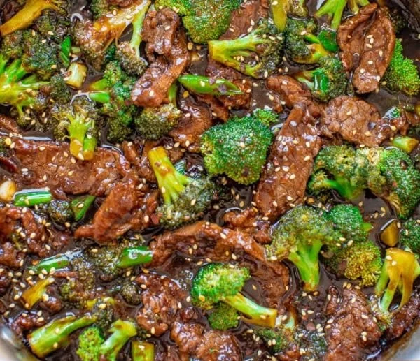Delicious homemade beef and broccoli served with rice on a plate.