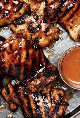 Plate of homemade hot honey chicken garnished with herbs and spices.
