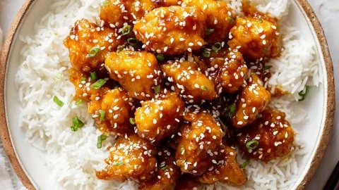 Delicious honey sesame chicken garnished with sesame seeds and green onions