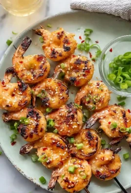 Juicy grilled Bang Bang shrimp skewers served with dipping sauce.