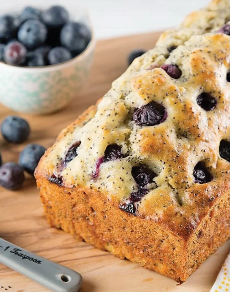 Lemon blueberry poppy seed loaf served on a wooden cutting board