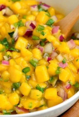 Bowl of fresh mango salsa with diced mango, onions, and cilantro