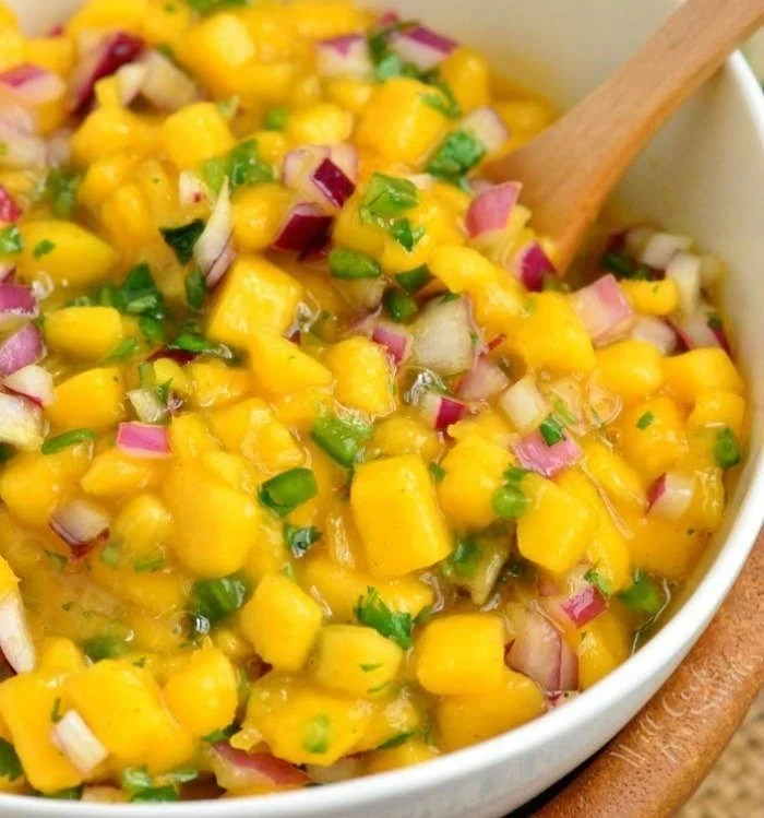 Bowl of fresh mango salsa with diced mango, onions, and cilantro