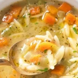Bowl of hearty Orzo Soup with vegetables and herbs