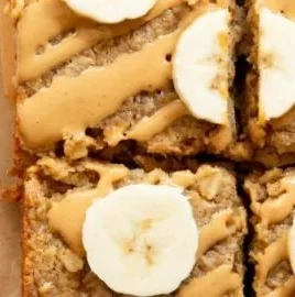 A slice of peanut butter banana baked oatmeal topped with banana slices and nuts.