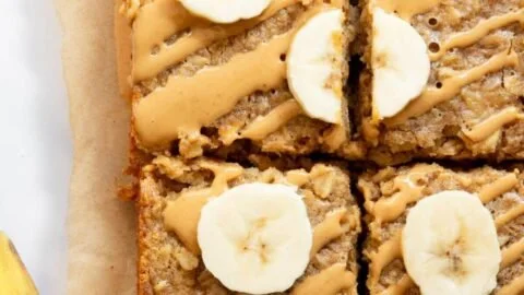 A slice of peanut butter banana baked oatmeal topped with banana slices and nuts.