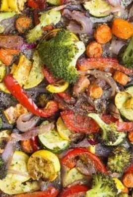 Plate of roasted garlic herb vegetables, including carrots, broccoli, and bell peppers.