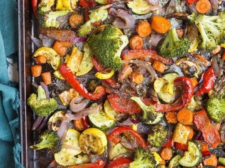 Plate of roasted garlic herb vegetables, including carrots, broccoli, and bell peppers.