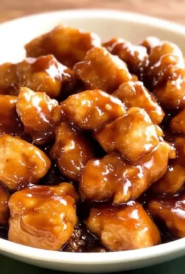 Delicious Slow Cooker Sticky Honey Chicken served on a plate with garnishes.