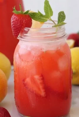Refreshing glass of strawberry lemonade with fresh strawberries and lemon slices