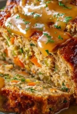 Savory Turkey Stuffing Meatloaf topped with herbs and spices, served on a plate