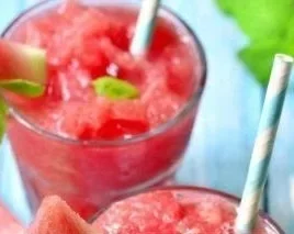 Refreshing watermelon smoothie served in a glass with mint leaves on top.