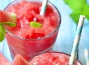 Refreshing watermelon smoothie served in a glass with mint leaves on top.
